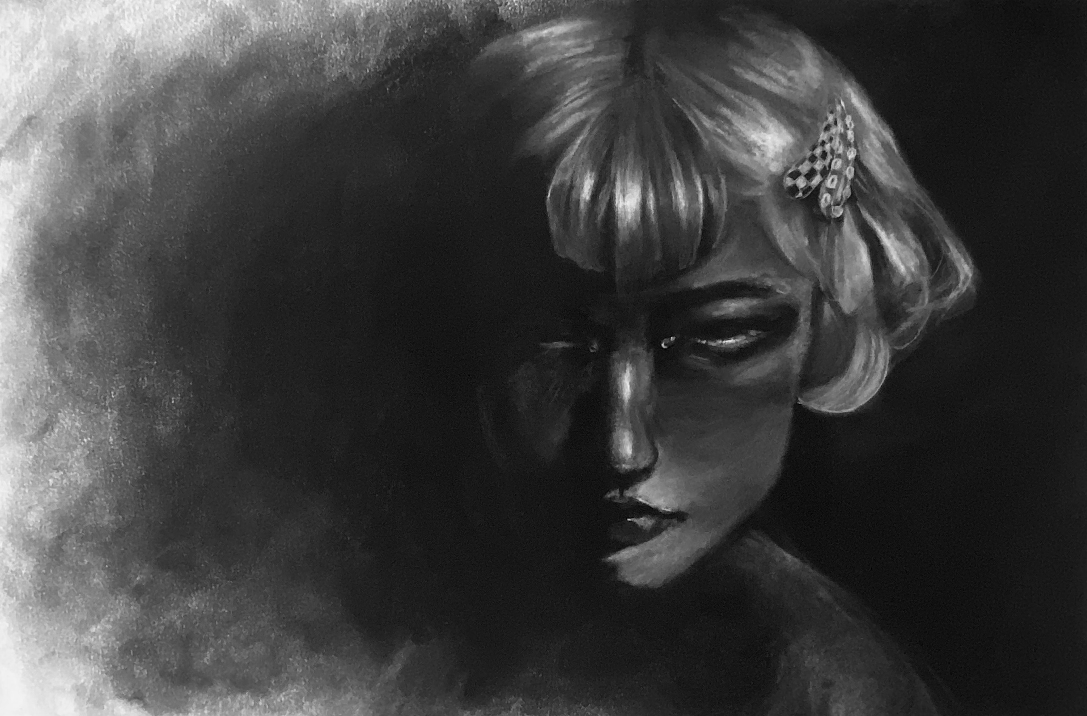 A graphite face emerges from a dark field beside chalky light.
